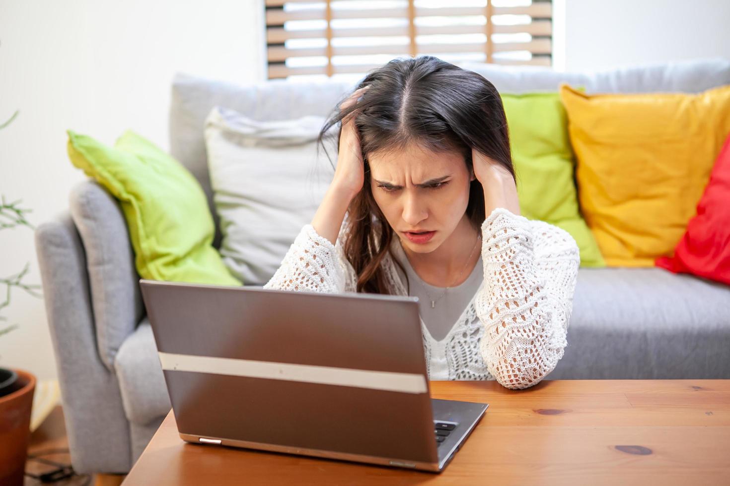 jeune femme avec ordinateur portable, employé de bureau fatigué et a mal à la tête. photo