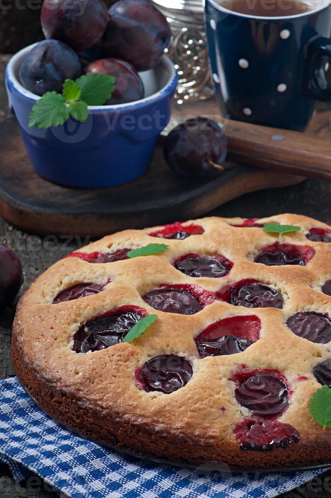 délicieux gâteau fait maison avec des prunes sur un fond de bois photo