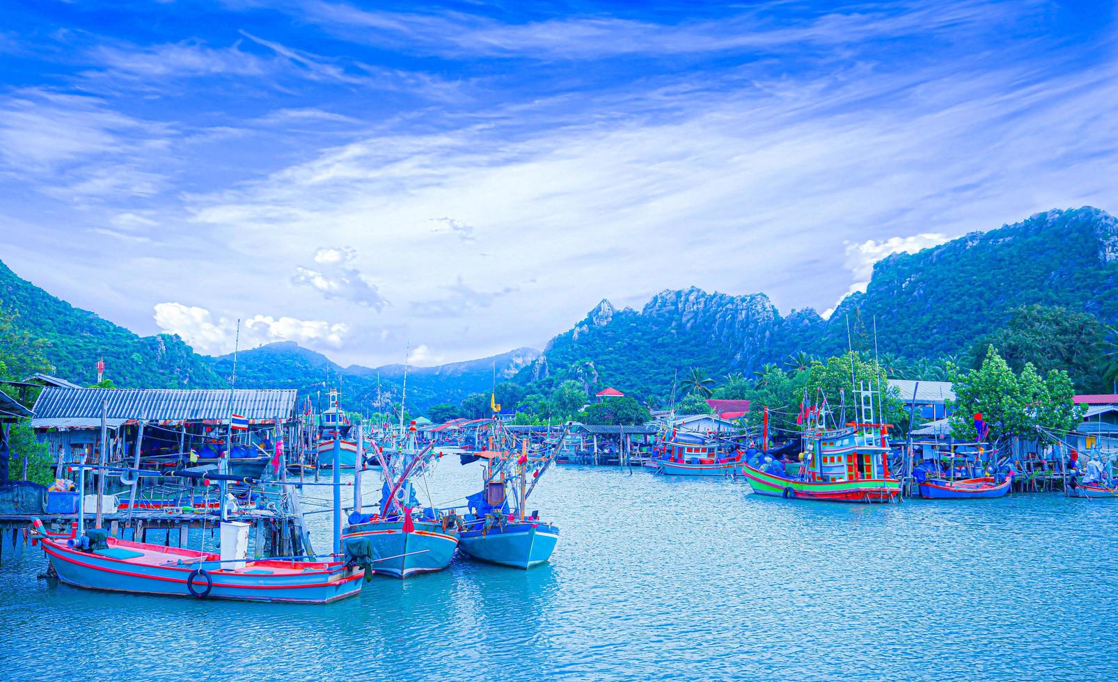 village de pêcheurs un en thaïlande, district de khao sam roi yot garer le bateau à la maison. un village marin au milieu des montagnes et de la mer, ciel clair. photo