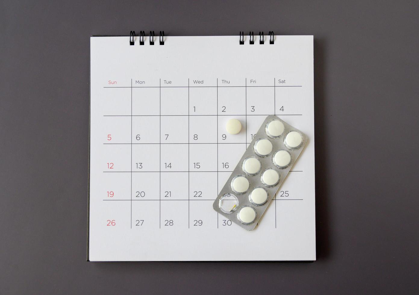 pilules sur un fond de calendrier. concept soins de santé photo