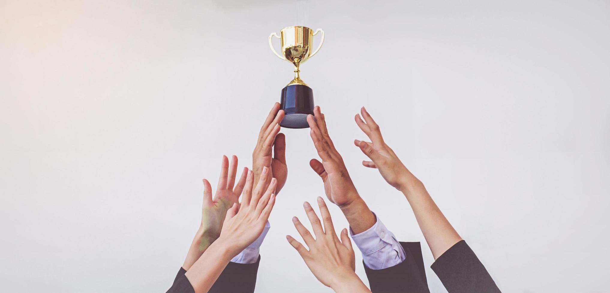 les mains se bousculent pour la coupe du trophée d'or, concept business photo