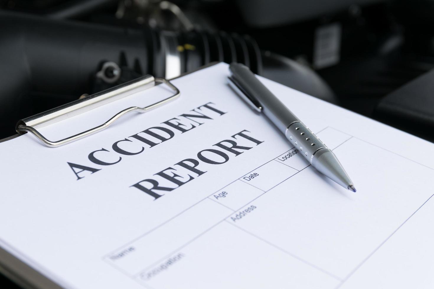 mécanicien inspectant la voiture endommagée et remplissant le formulaire de rapport d'accident photo