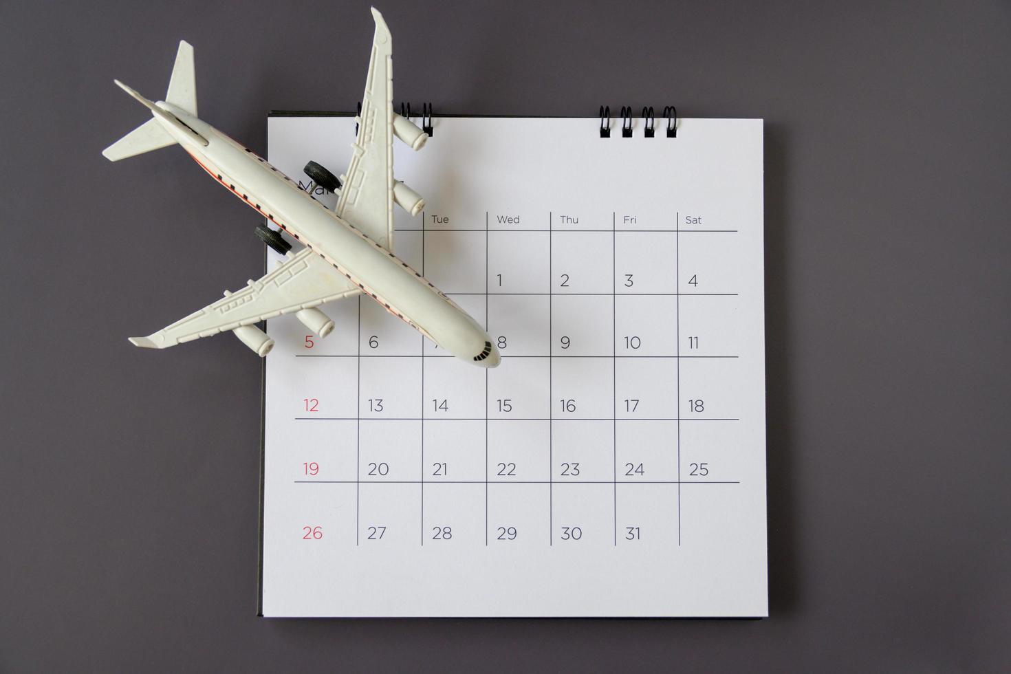modèle d'avion avec calendrier papier. planifier un voyage photo