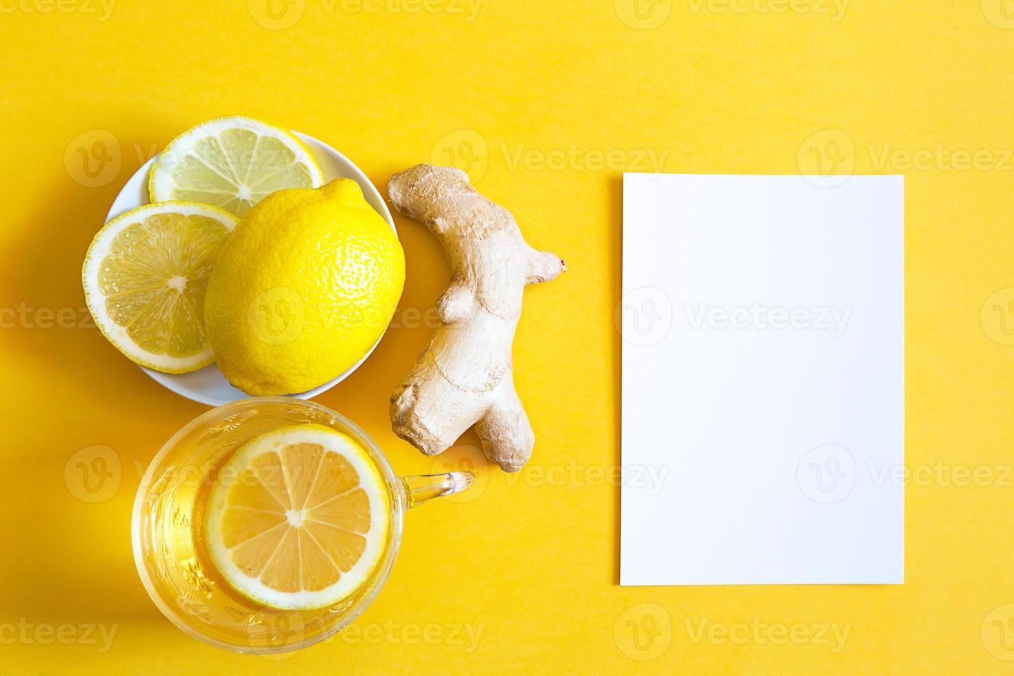 thé médicinal dans une tasse, gingembre, citron renforcent le système immunitaire pendant la saison froide et copiez l'espace, feuille pour les notes. boisson vitaminée pour la santé et ingrédients sur fond jaune éclairant. photo