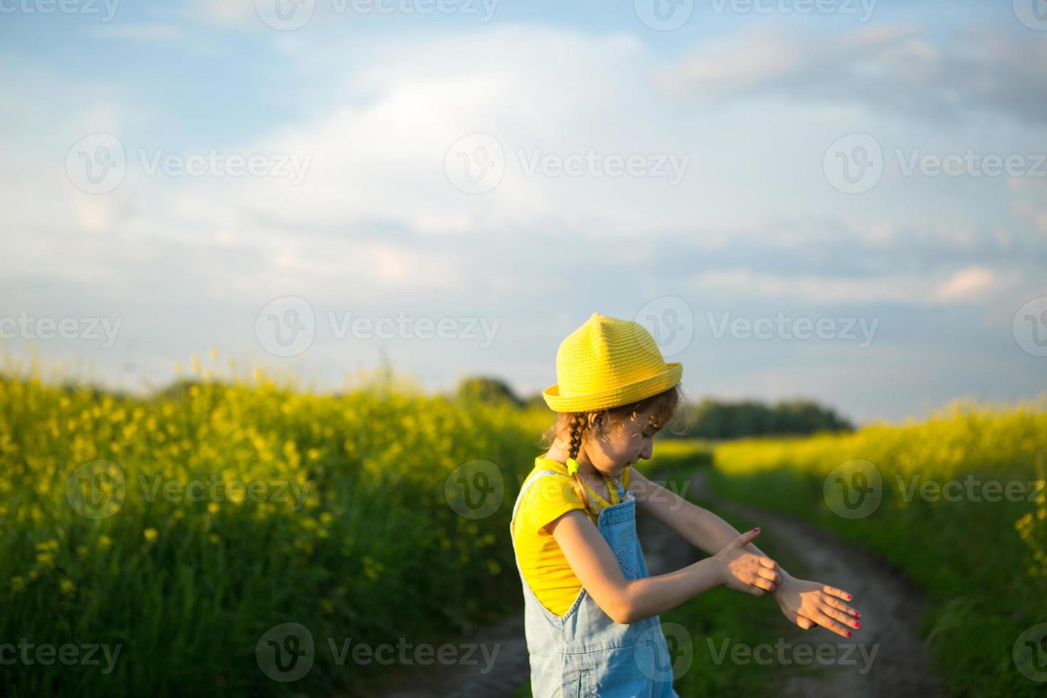 fille tue les moustiques sur ses mains et ses pieds. l'enfant se tape sur le corps, gratte les endroits des piqûres, protection contre les piqûres d'insectes, répulsif sans danger pour les enfants. loisirs de plein air, contre les allergies photo