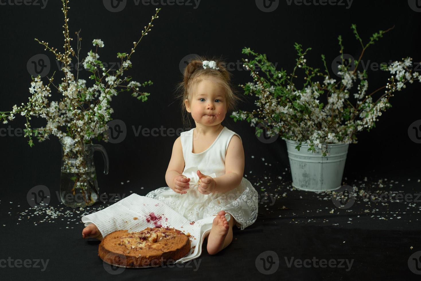 petite fille fête son premier anniversaire. fille mangeant son premier gâteau. photo