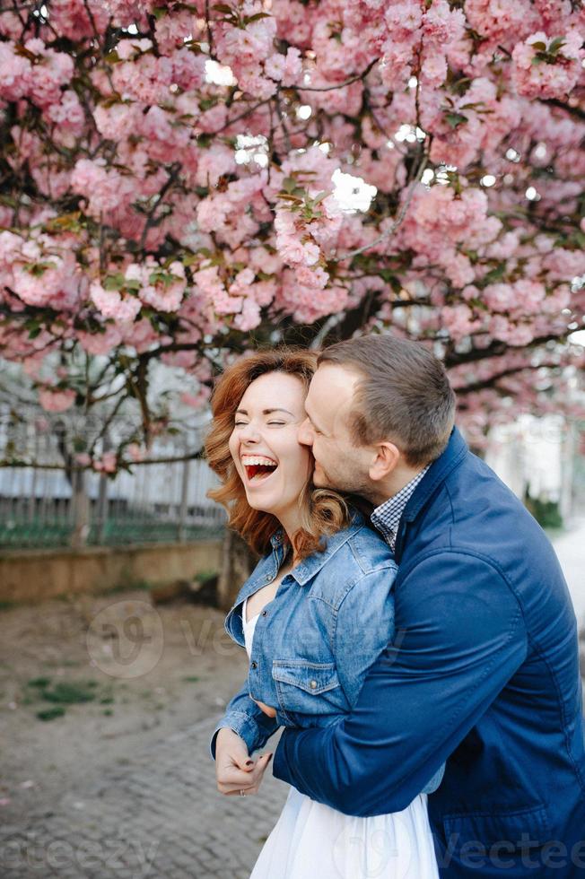 couple amoureux dans un verger de pommiers en fleurs allongé sur la couverture photo