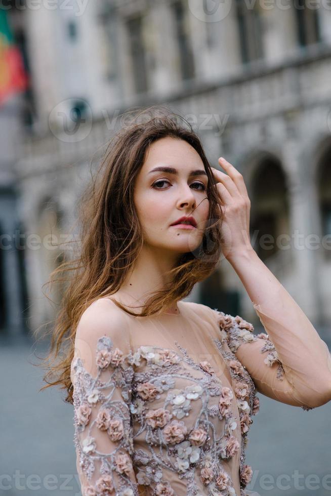 portrait d'une jolie jeune fille vêtue d'une robe luxuriante se promenant dans le parc et le grand palais photo