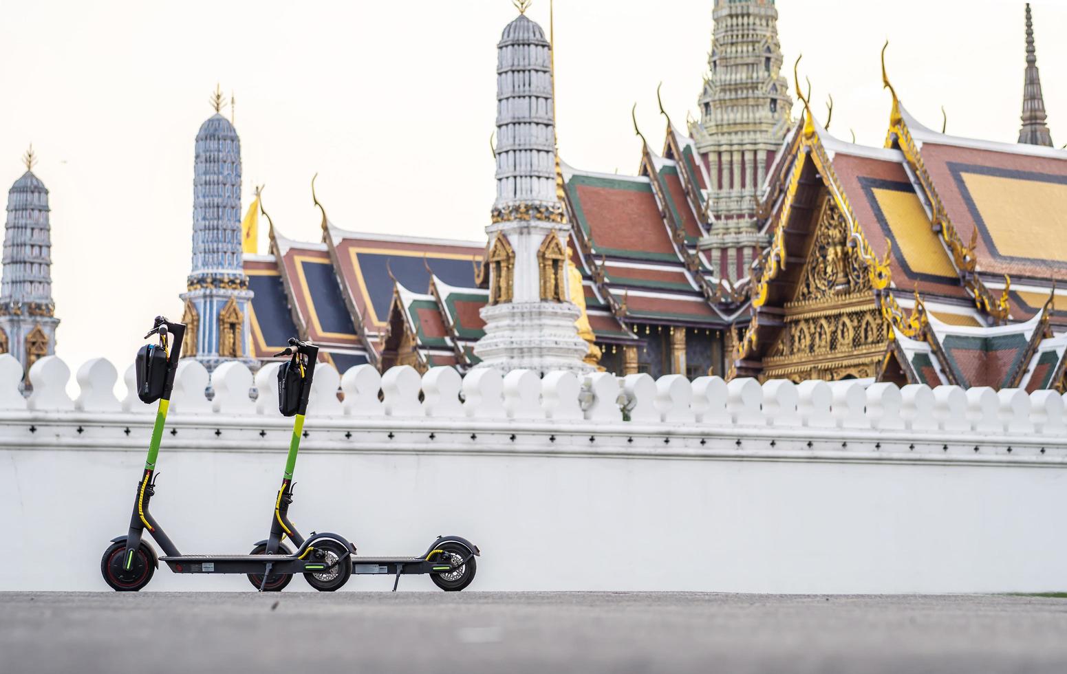 e-scooter garé devant le temple wat phra kaew du bouddha d'émeraude. photo