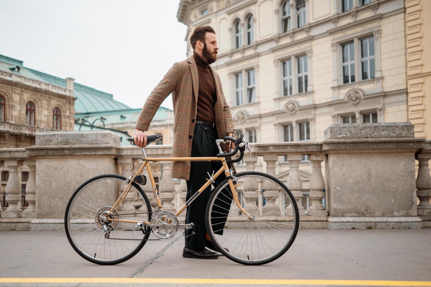 jeune homme d'affaires avec vélo sur fond de mur rouge dans une ville. fond de couleur rouge photo