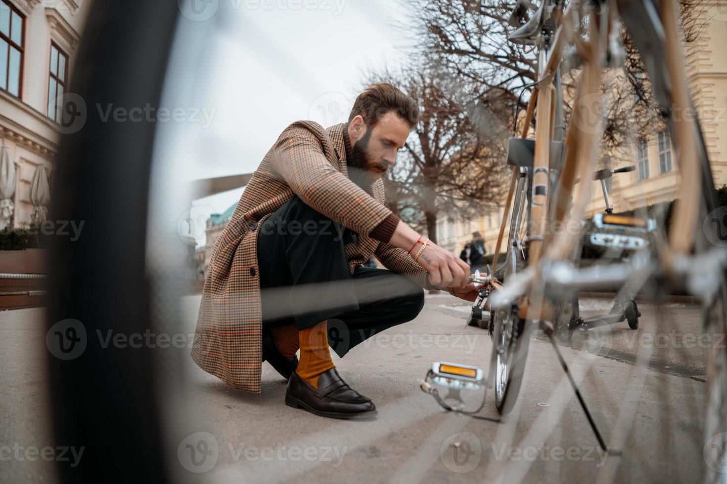 homme vérifiant les roues du vélo. réparer un vélo dans la rue. photo