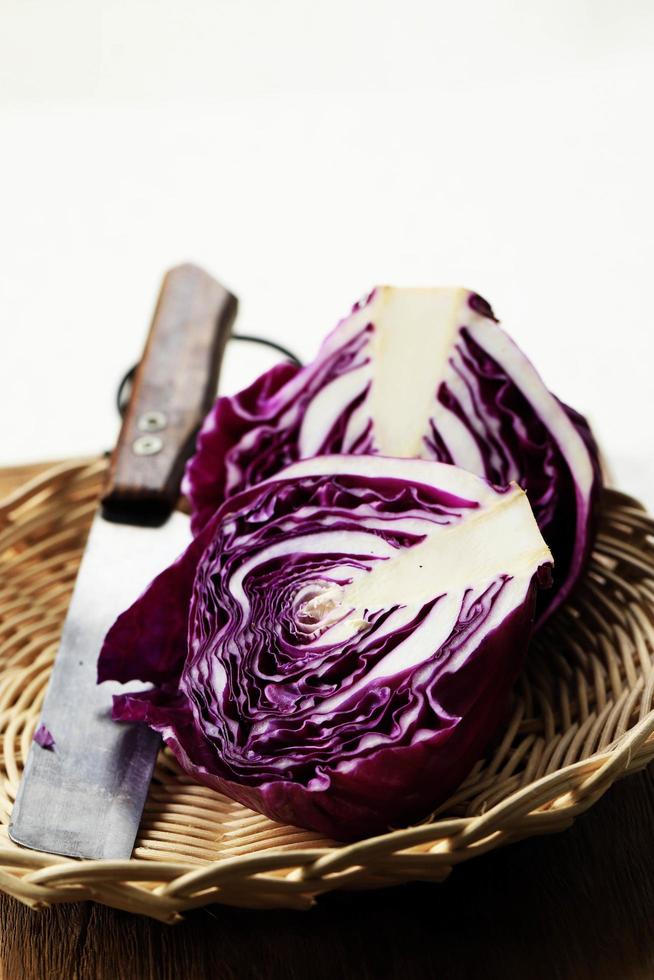 tranché et un ensemble de légumes de chou violet sur le dessus d'une table en bois photo