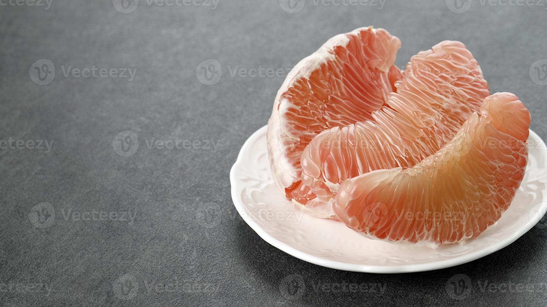 fruit de pomelo sur assiette. pamplemousse, jeruk bali ou pomelo de bali. les grosses oranges en indonésie sont connues sous le nom d'oranges de bali ou jeruk bali. photo