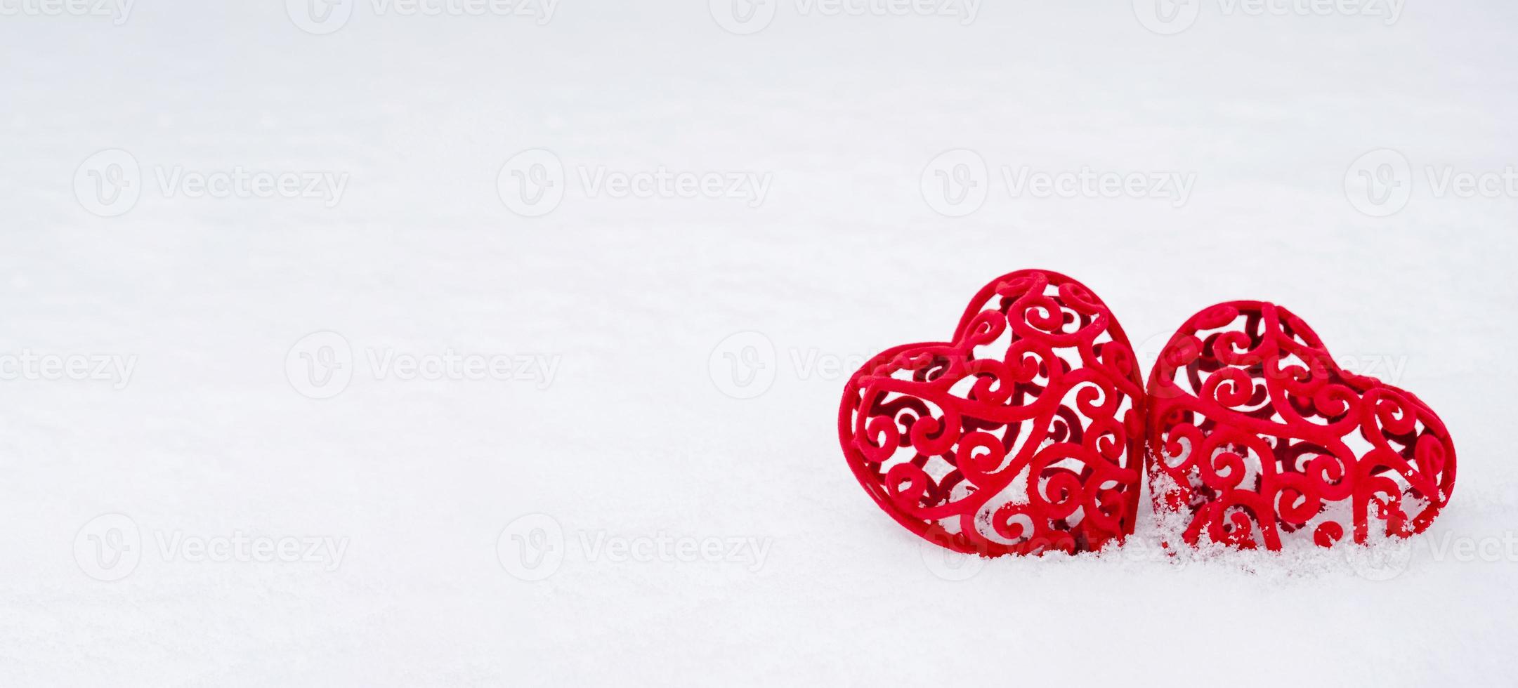 deux coeurs rouges dans la neige - une carte de voeux pour la saint valentin, la fête de tous les amoureux le 14 février. copiez l'espace. invitation à un rendez-vous, amour, rencontres photo