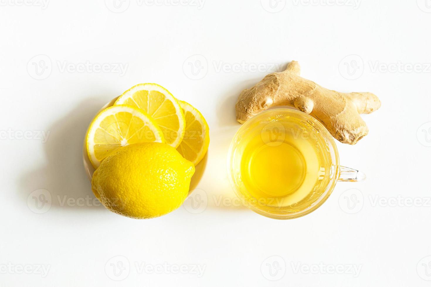 thé médicinal dans une tasse, gingembre, citron renforcent le système immunitaire pendant la saison froide. boisson vitaminée pour la santé et les ingrédients sur fond blanc. photo