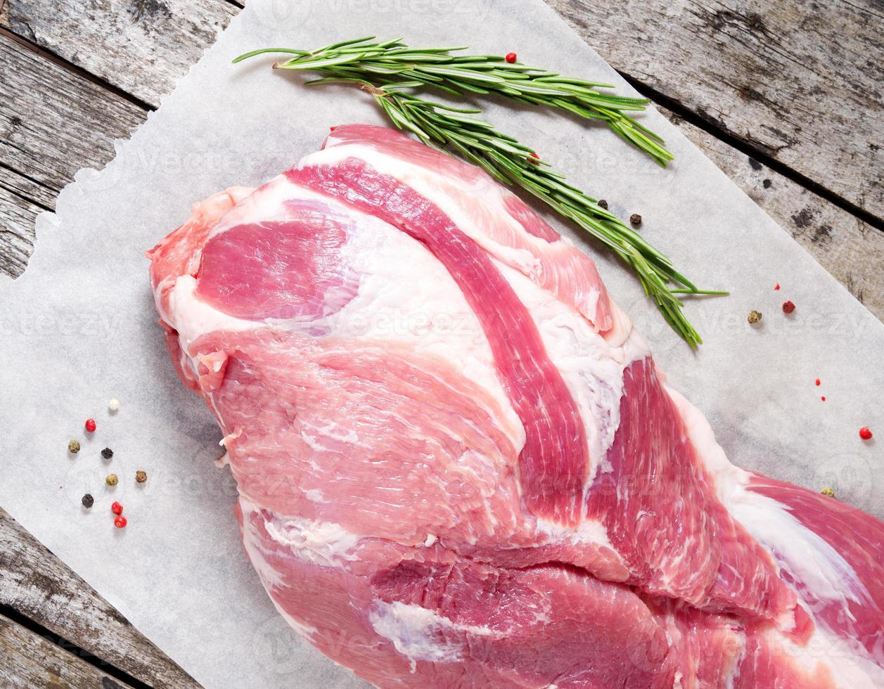 cou de porc frais cru, gros morceau entier sur du papier parchemin blanc, sur une vieille table en bois grise dans la cuisine, vue de dessus photo