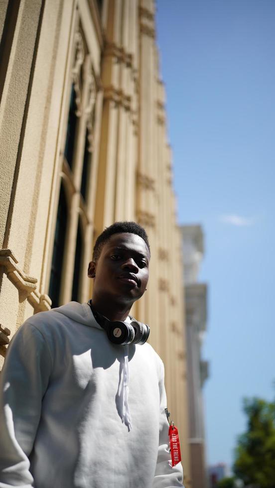 homme afro-américain s'amusant à marcher dans le centre-ville - jeune homme heureux profitant d'un coucher de soleil en plein air - mode de vie de la génération du millénaire et concept d'attitude positive des personnes photo