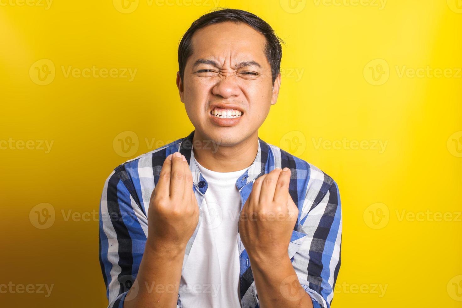 portrait d'un homme asiatique malheureux avec un geste de la main de protestation isolé sur fond jaune photo