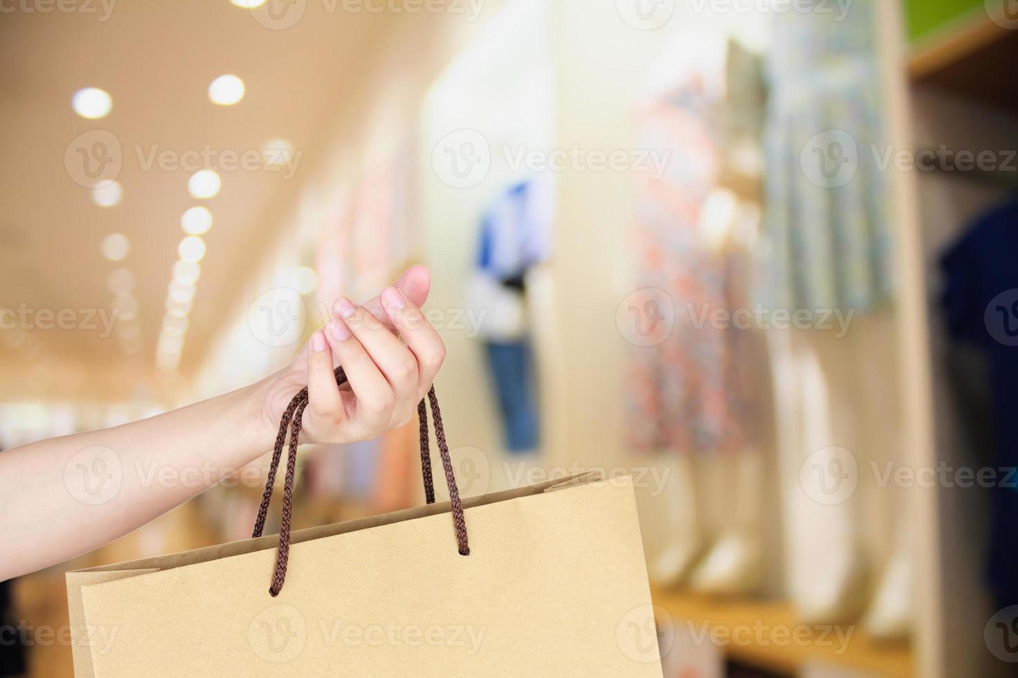 Main tenir le sac à provisions dans un magasin de vêtements photo