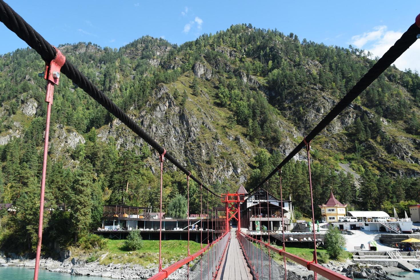 pont suspendu au-dessus de la rivière de montagne photo