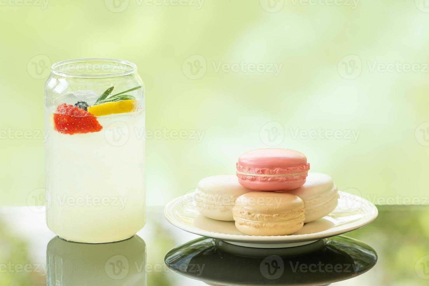 Délicieux soda au citron frais juteux sur table en verre fond de réflexion de feuille floue photo