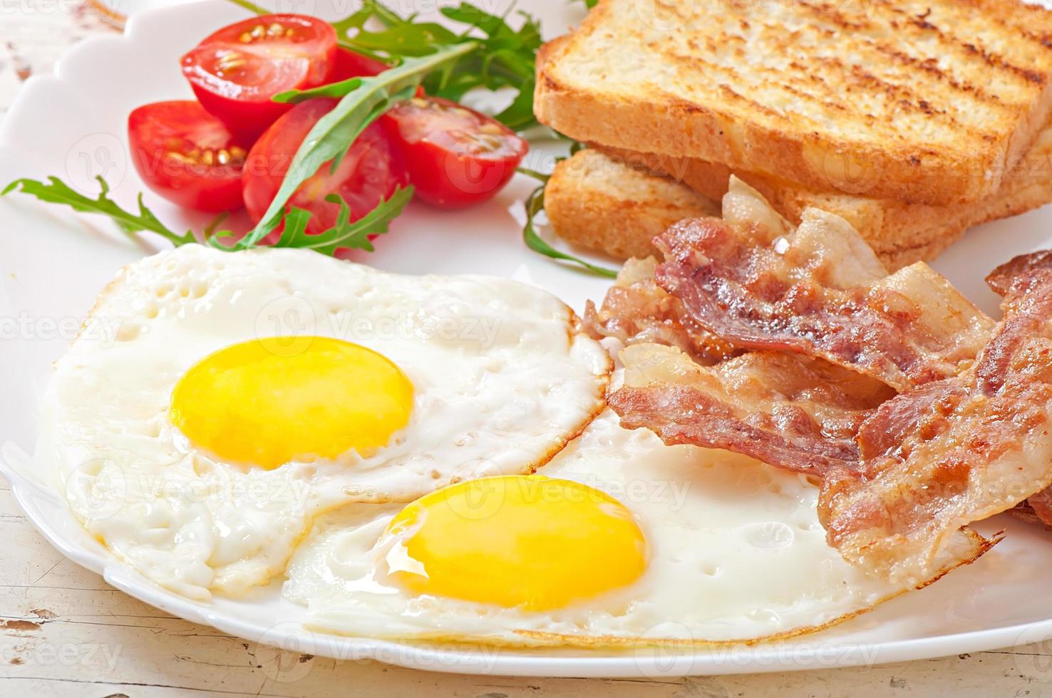 petit-déjeuner anglais - pain grillé, œuf, bacon et légumes photo