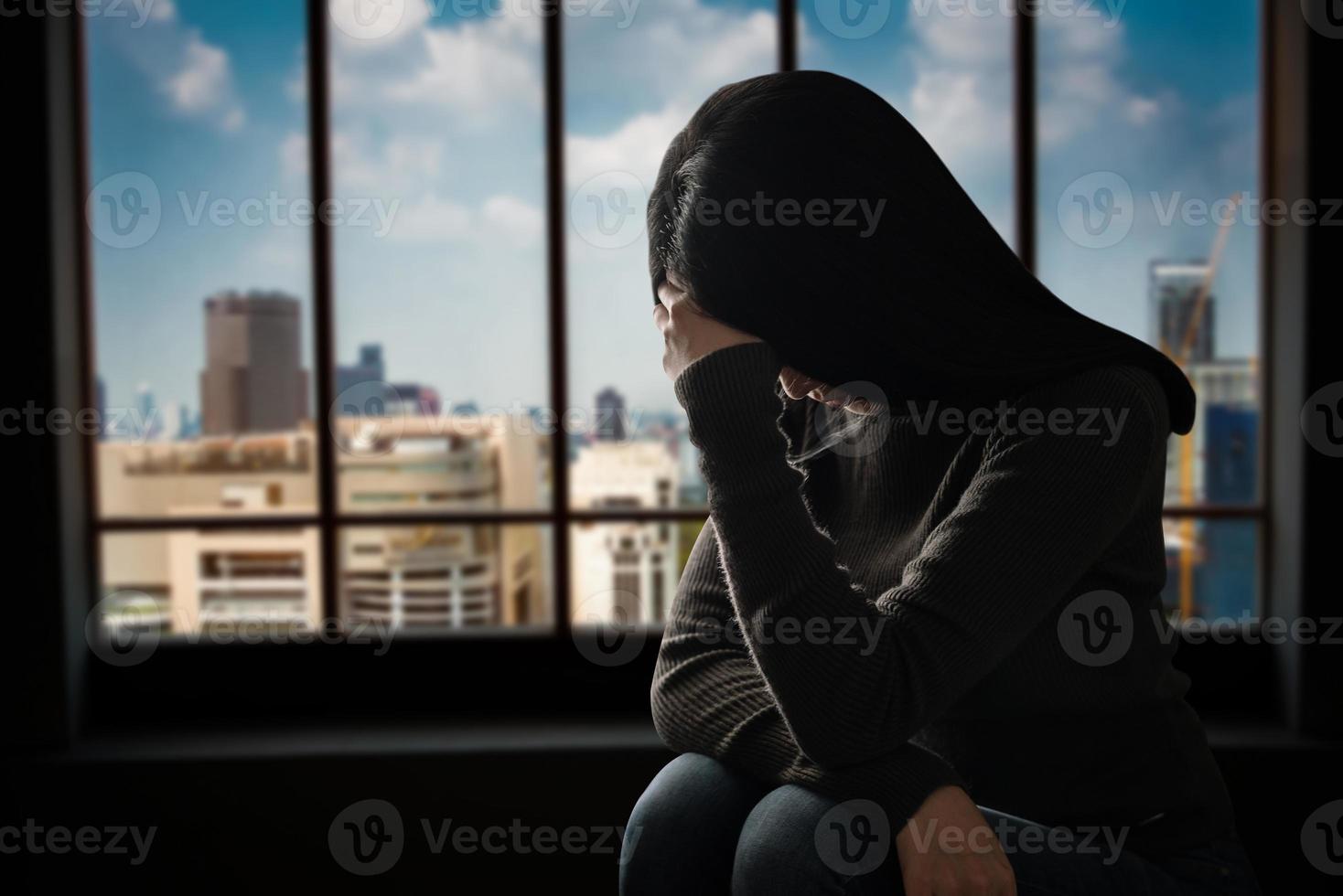 femme assise dépression debout près de la fenêtre photo