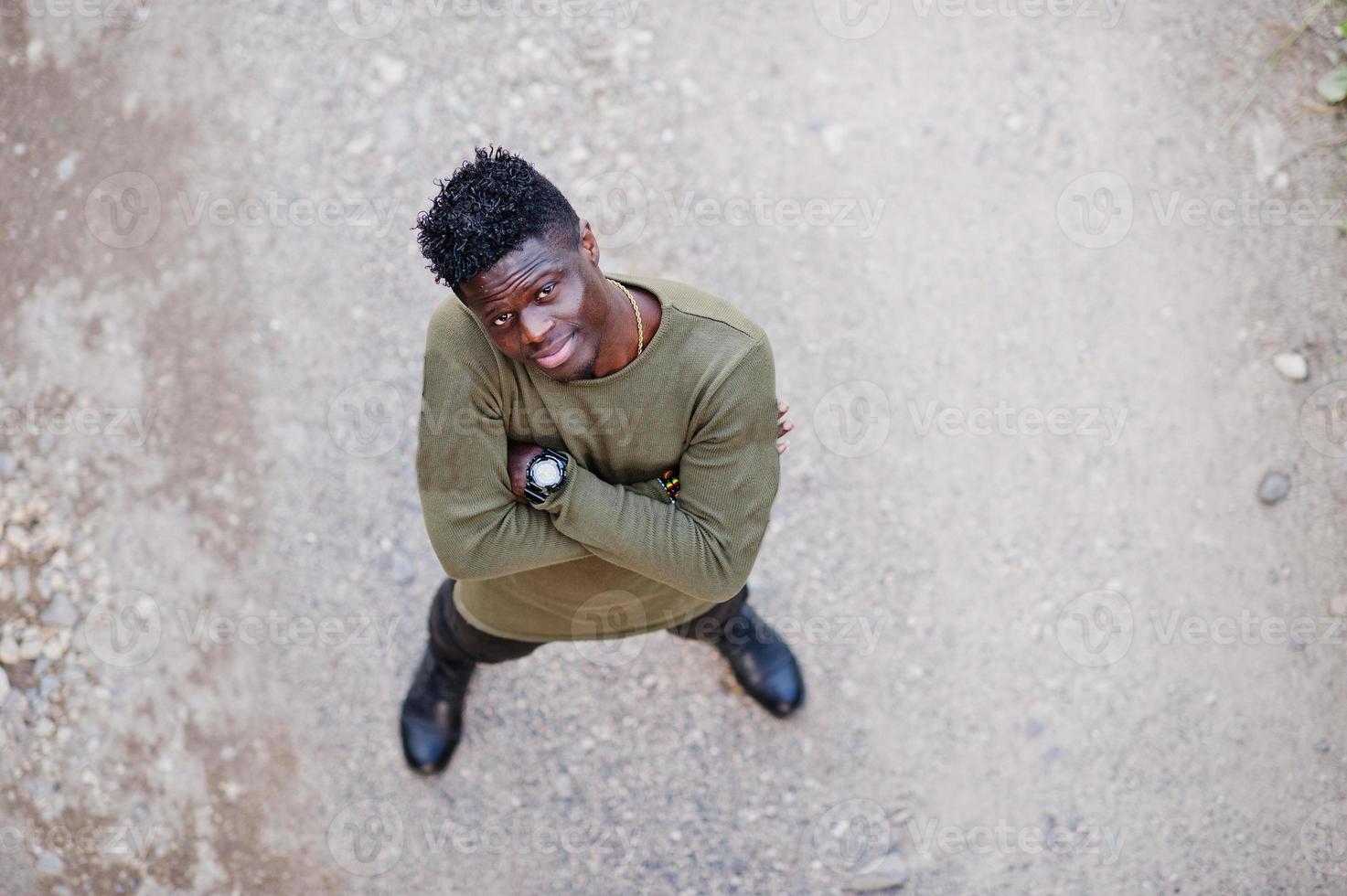 séduisant jeune homme afro-américain en vêtements décontractés debout sur le chemin de terre. photo