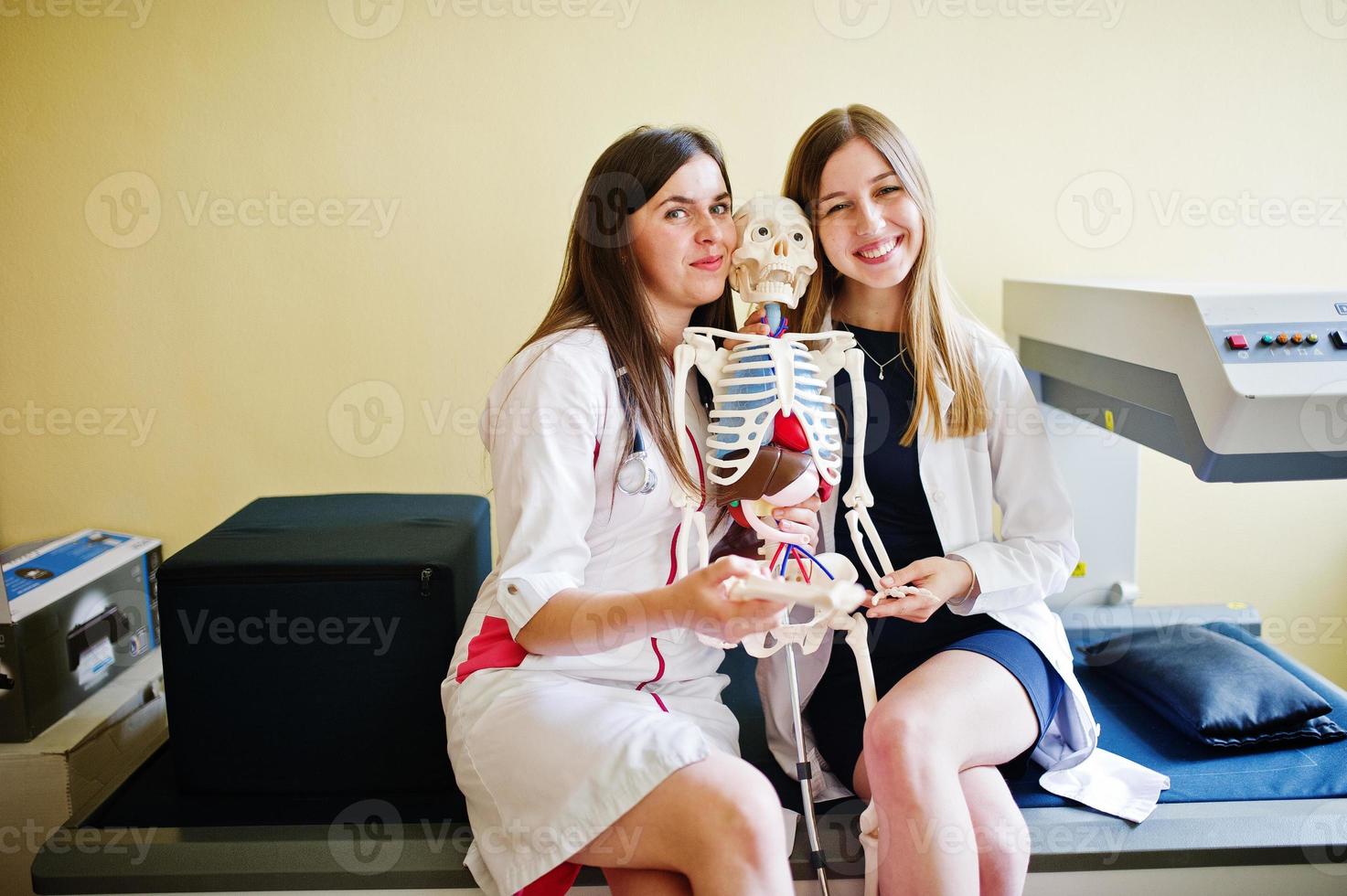 jeunes médecins s'amusant en posant avec un squelette. photo