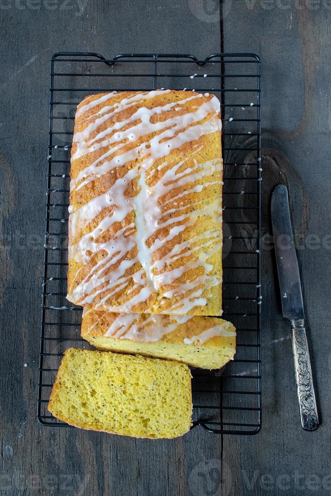 pain de gâteau aux graines de pavot au citron cuit au four avec une bruine de glaçage blanc mise à plat photo