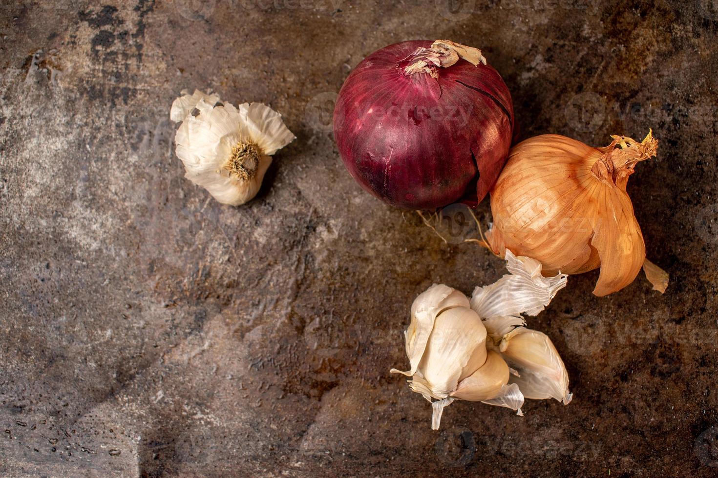 oignons et ail isolés sur fond de métal foncé à plat photo