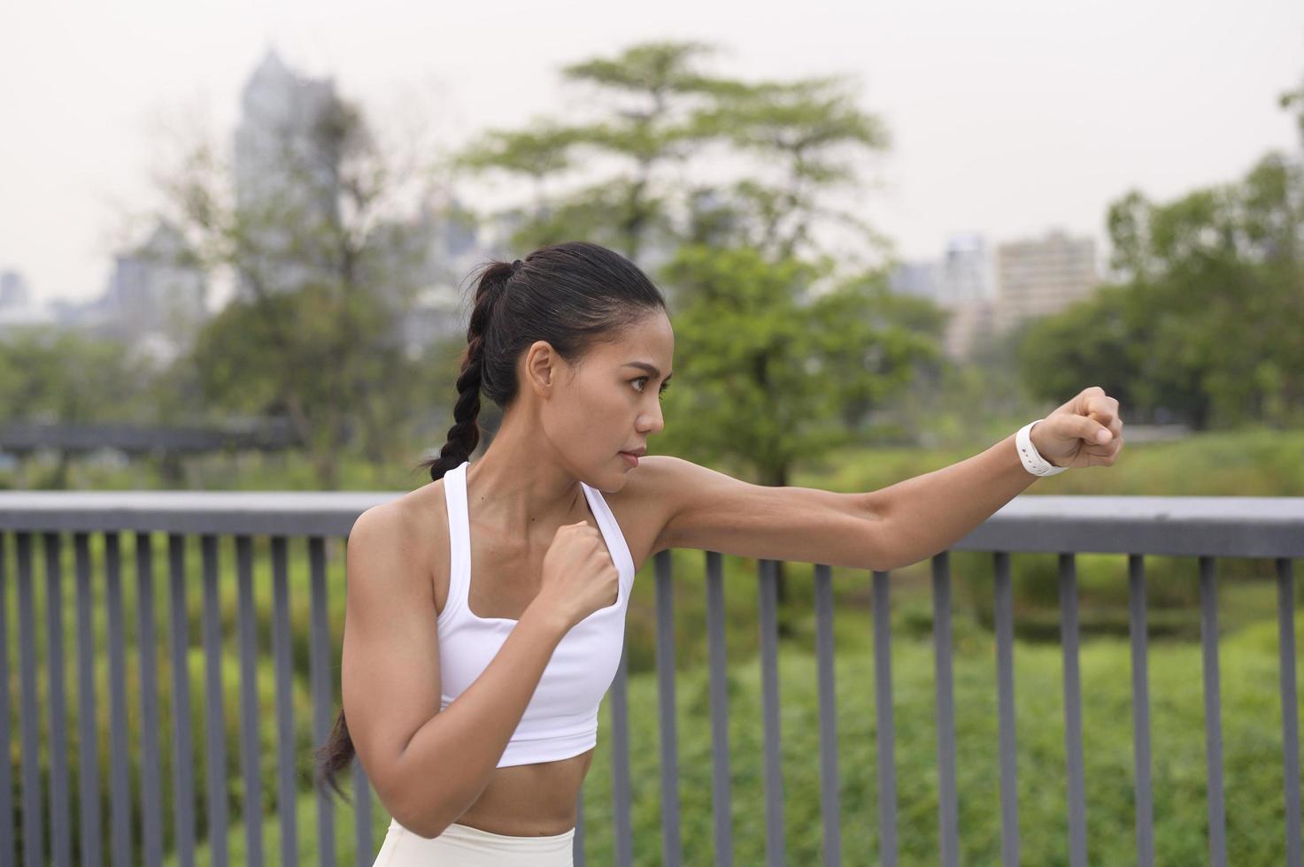 jeune femme de remise en forme en boxe de vêtements de sport dans le parc de la ville, saines et modes de vie. photo