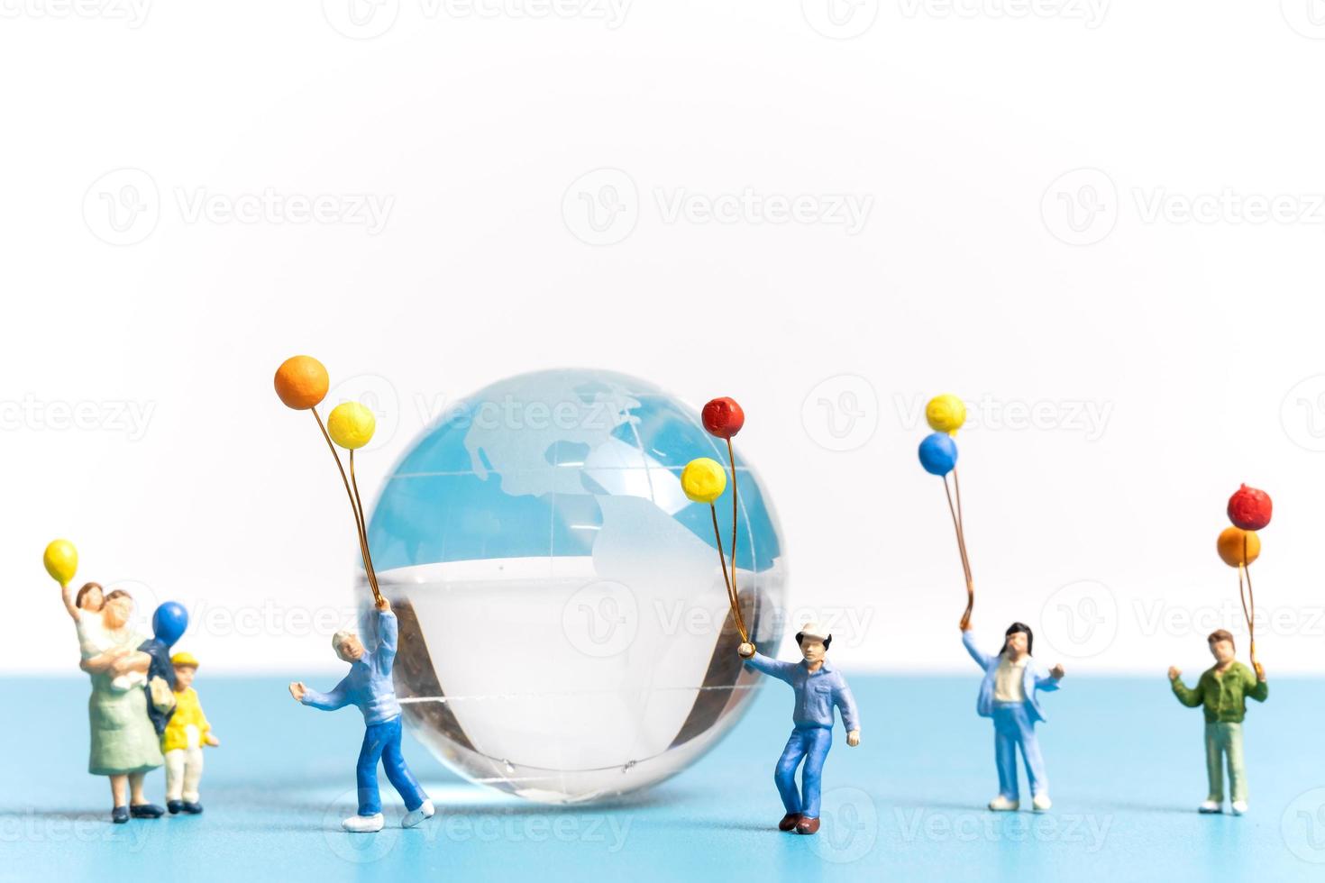personnes miniatures enfant tenant un ballon avec un globe de cristal photo