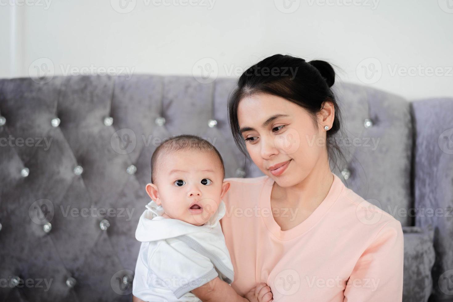 bébé asiatique mignon et nouveau-né. famille heureuse, jeune mère asiatique avec un visage souriant et heureux portant et prenant soin avec amour. petit nouveau-né innocent au premier jour de sa vie. notion de fête des mères. photo