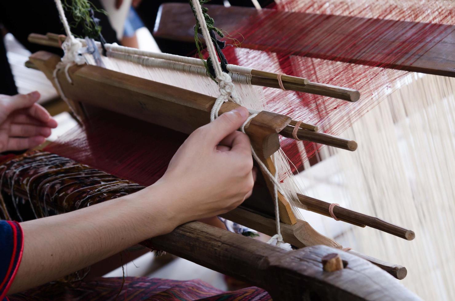 métiers à tisser indigènes thaïlandais pour le tissage de tissus de soie, vêtements de tissage fabriqués à la main en thaïlande. les beaux vêtements artisanaux asiatiques et les connaissances de la sagesse locale. photo