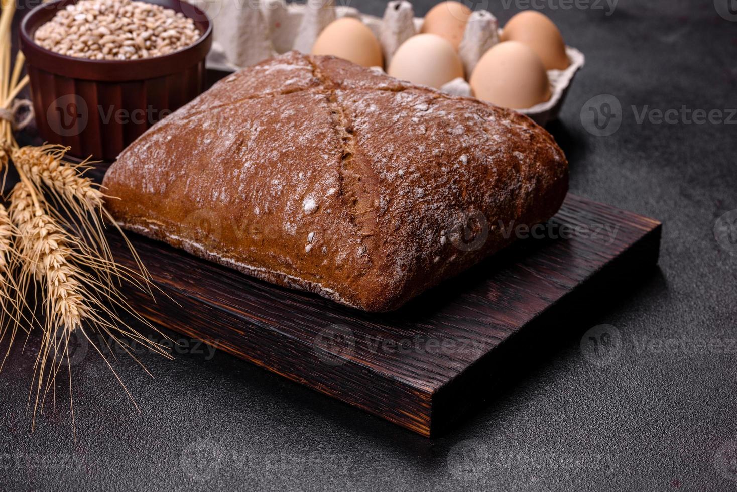 beau pain brun savoureux en forme de carré sur fond de béton foncé photo