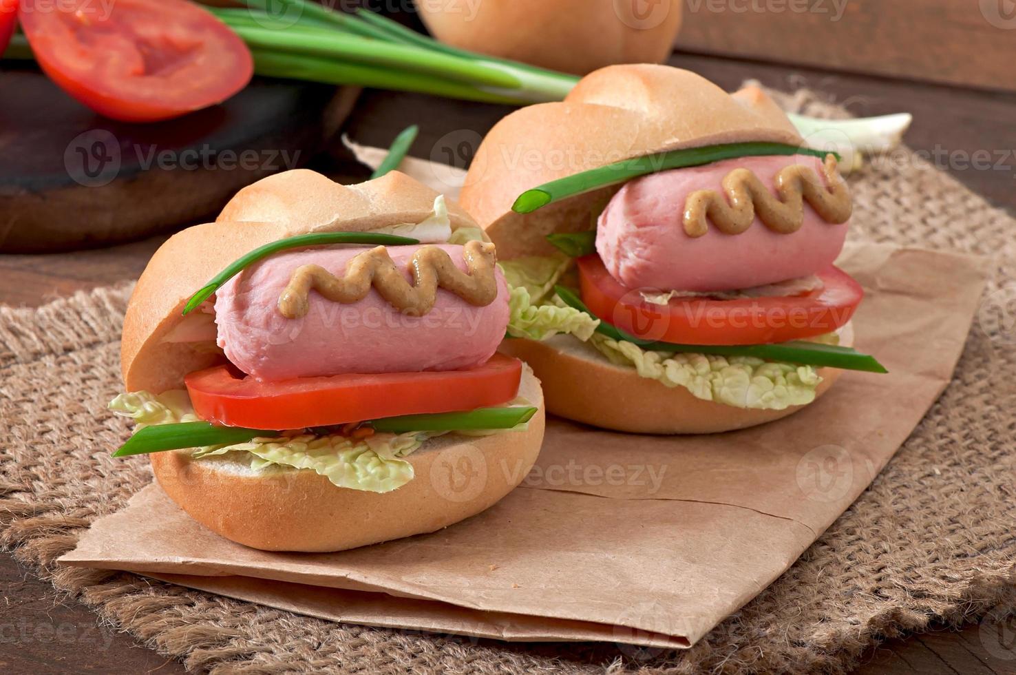 petit hot-dog joyeux avec saucisse et tomate photo