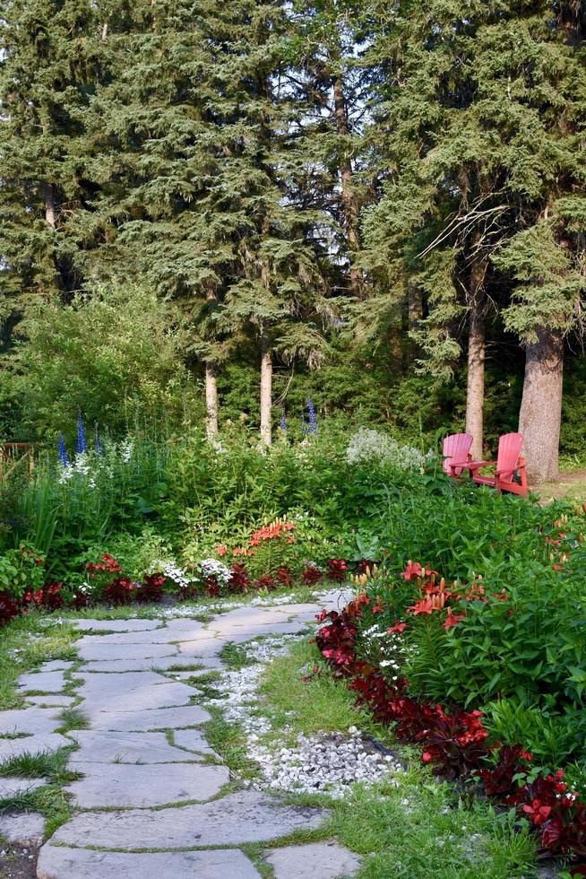 un chemin dans un parc mène à deux chaises rouges photo