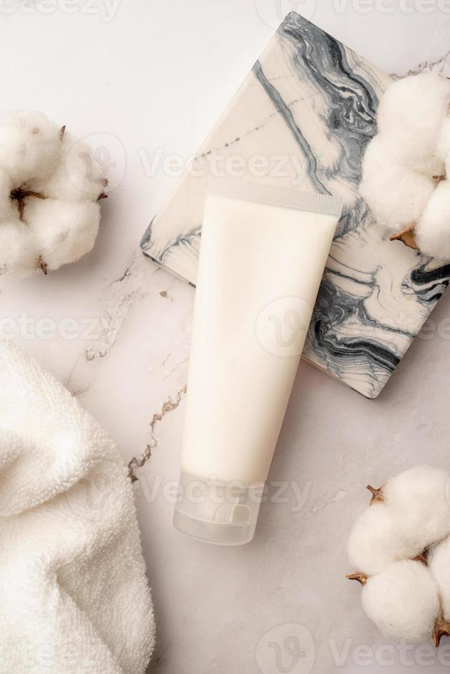 vue de dessus maquette produit de soin du visage tube blanc avec étiquette vierge sur fond de marbre photo