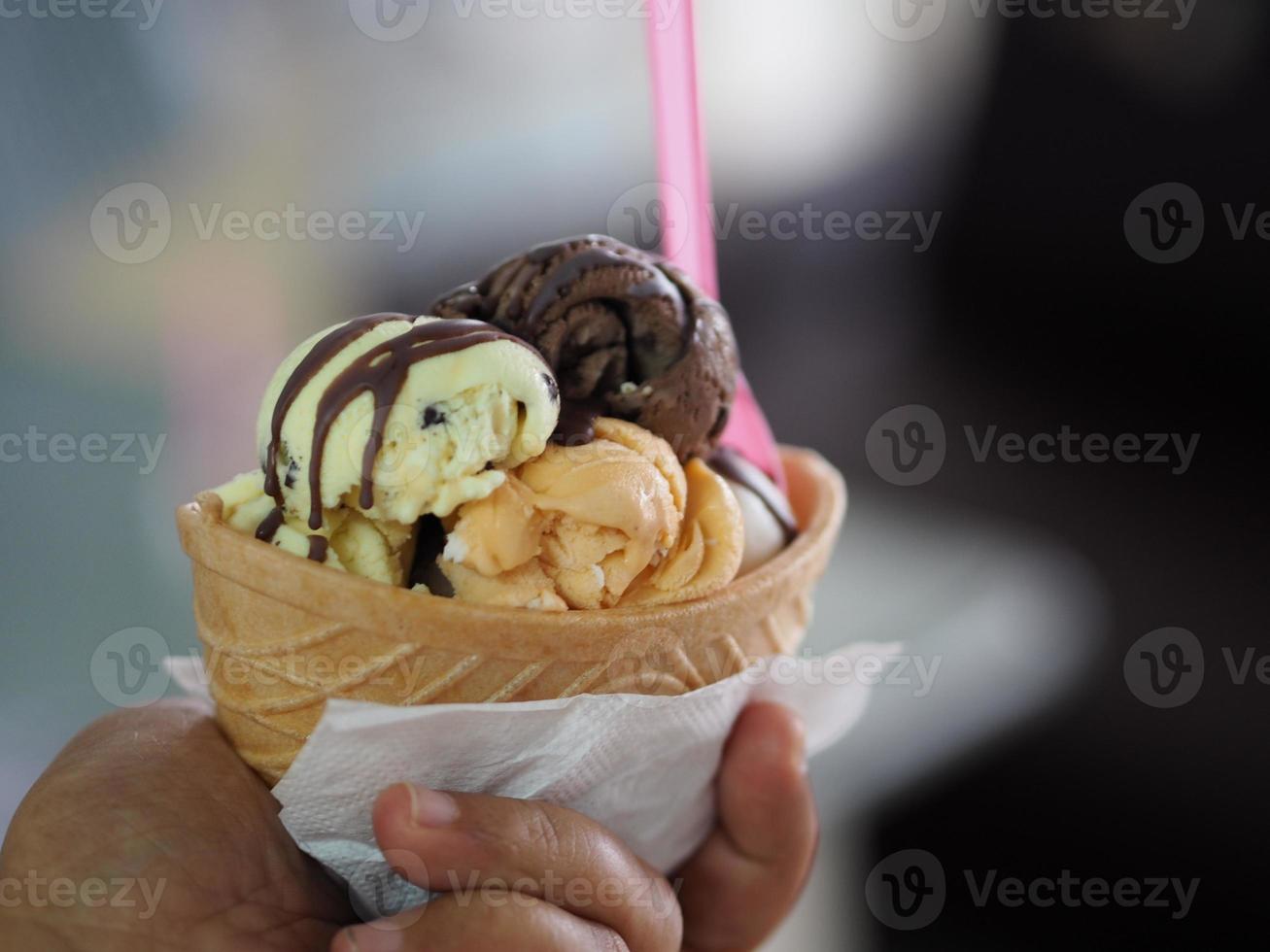 chocolat, thé thaï à l'orange, glace au lait de coco dans une tasse de gaufre croustillante dans la main de la femme photo