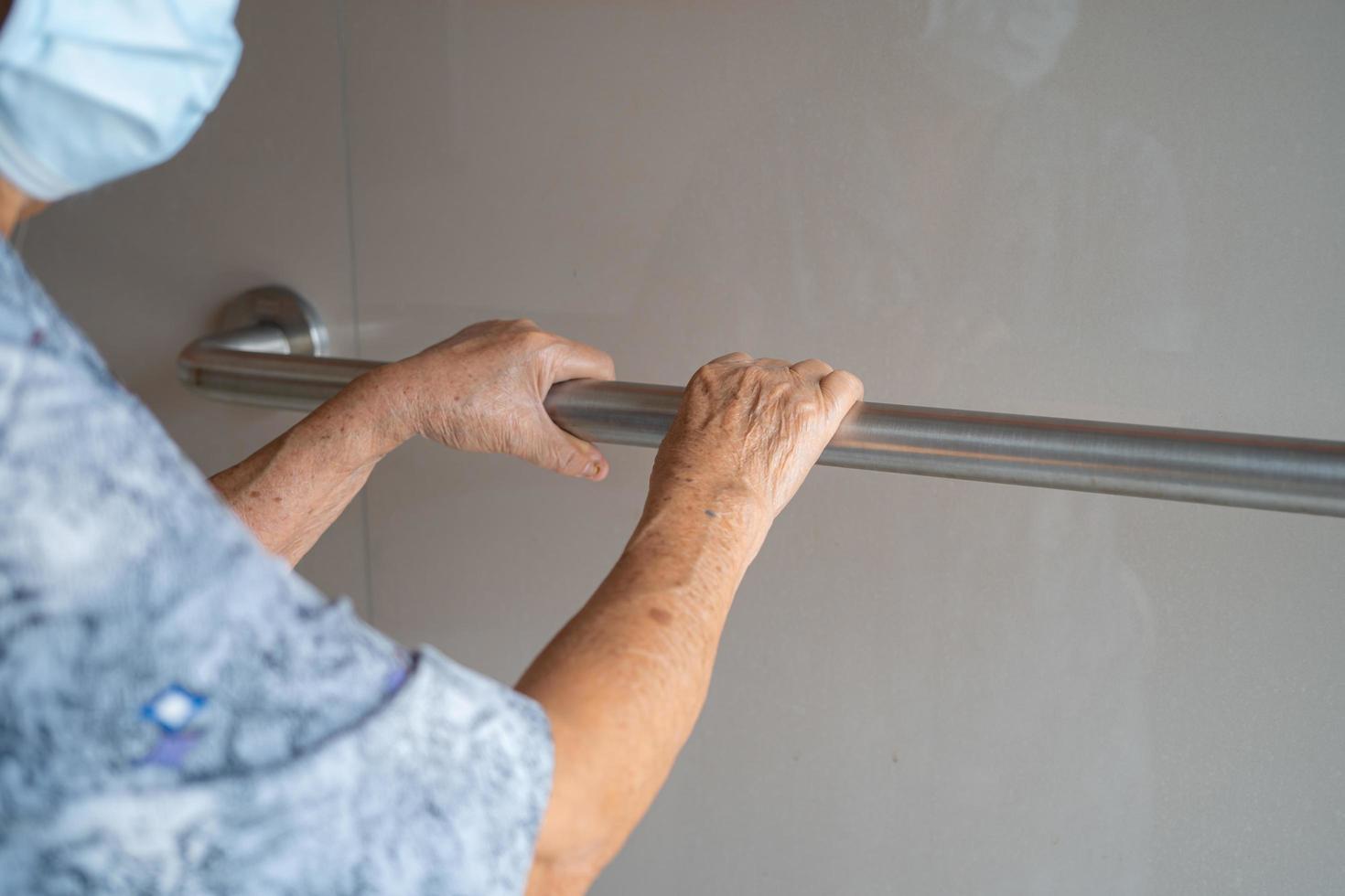 Une patiente asiatique âgée ou âgée utilise la sécurité de la poignée de la salle de bain des toilettes dans la salle d'hôpital de soins infirmiers, concept médical solide et sain. photo