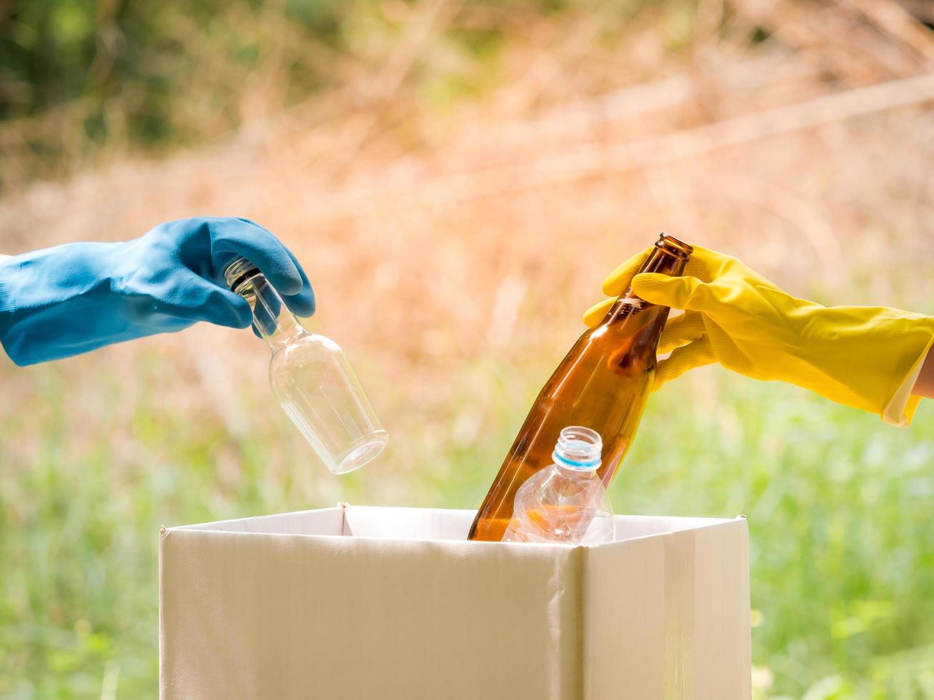 des bénévoles ramassent des bouteilles d'eau en plastique dans la zone du parc, auprès de personnes qui refusent de les jeter à la poubelle dans une boîte en papier pour les recycler photo