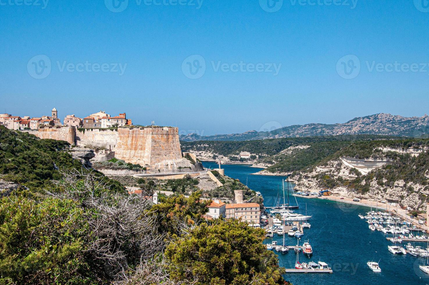 belle vue sur le bastion de l'etendard à bonifacio, france avec des navires et des collines en arrière-plan photo