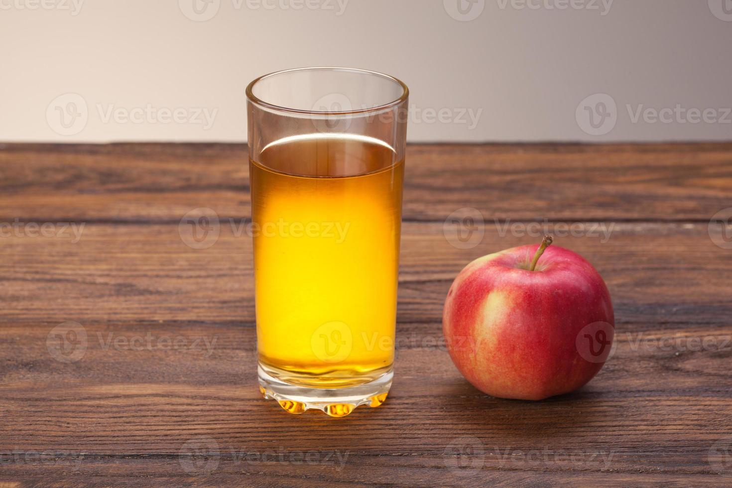 verre de jus de pomme et pomme rouge sur bois photo