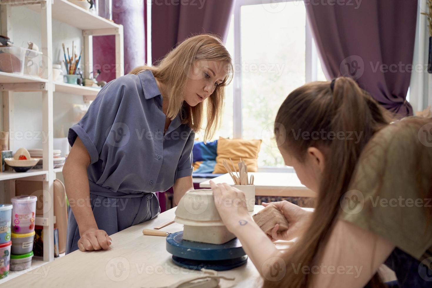 master-class sur la fabrication d'ustensiles en argile, une femme enseigne une autre sur l'atelier photo