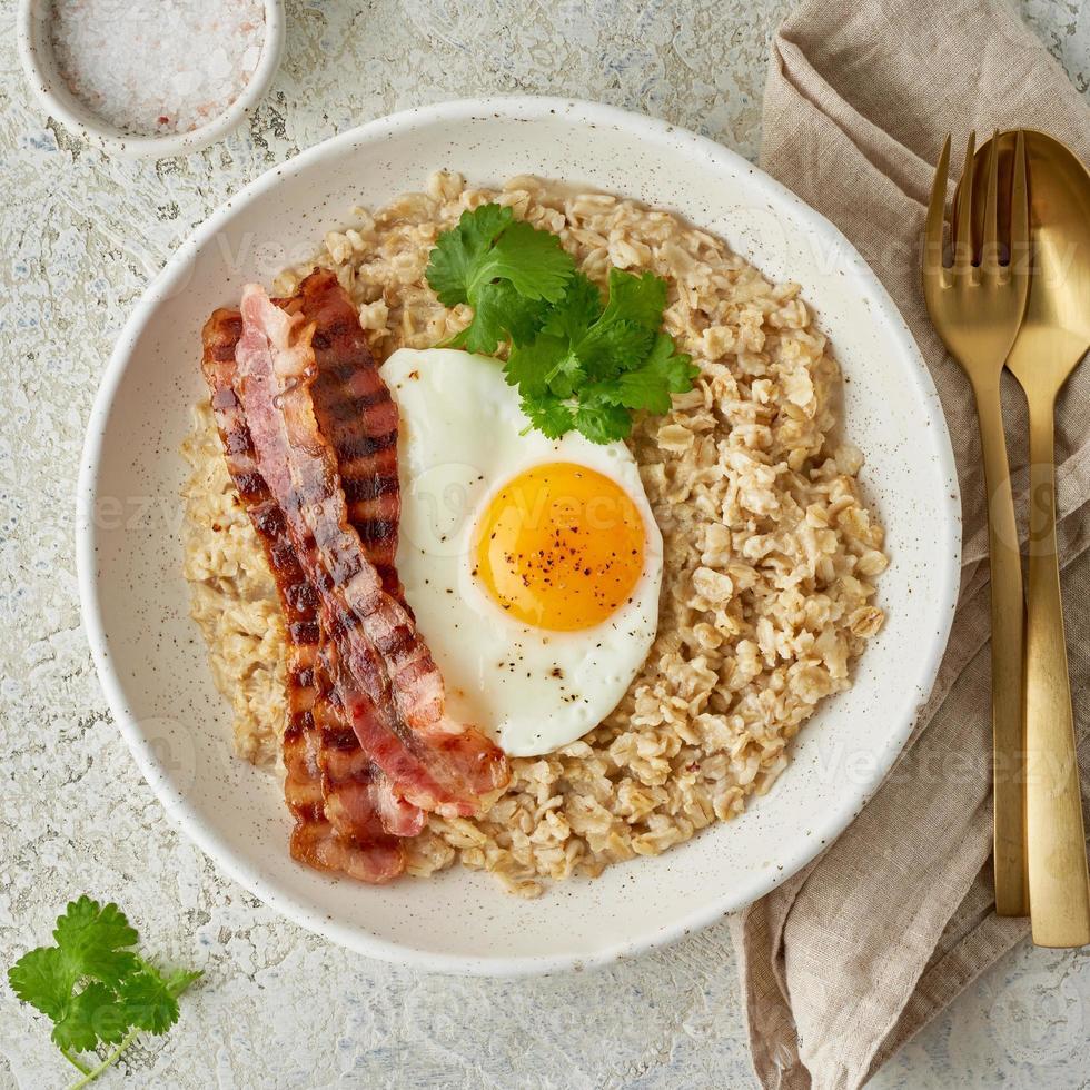 flocons d'avoine, œuf au plat, bacon frit. copieux petit-déjeuner riche en calories, vue de dessus photo