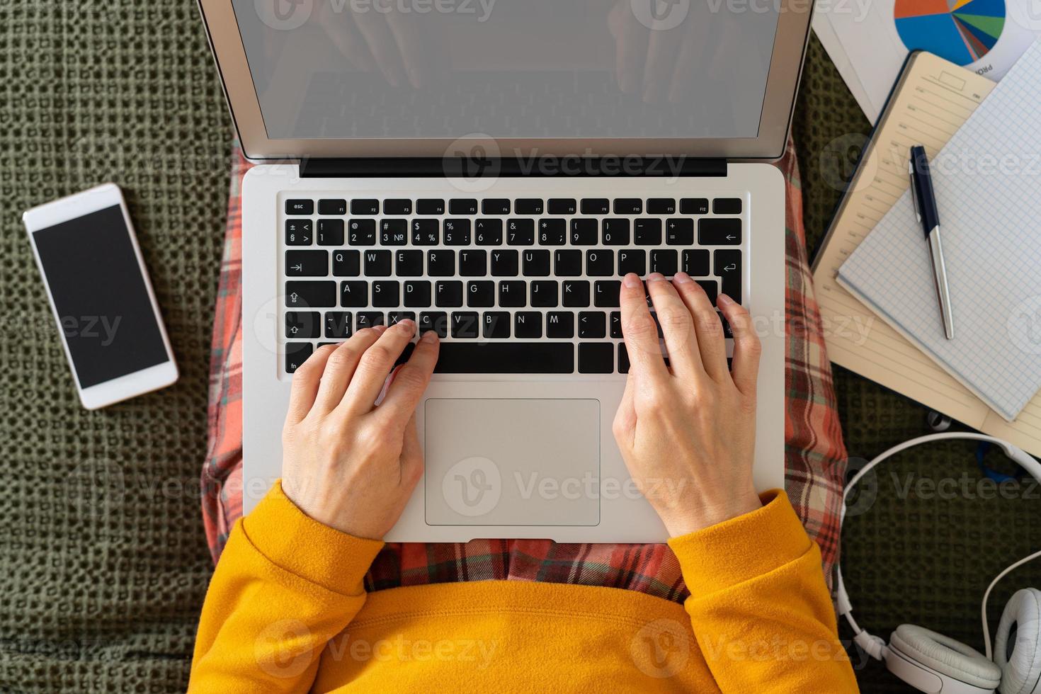 vue de dessus travail à la maison. l'enseignement à distance. femme tapant sur un blog sur un ordinateur portable photo