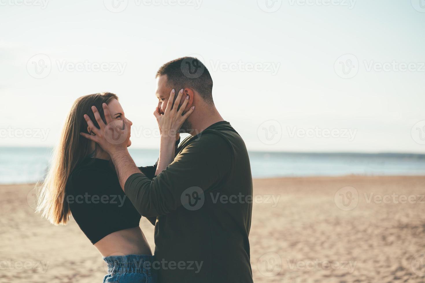 jeune couple adulte debout sur la côte et se poussant le nez. photo