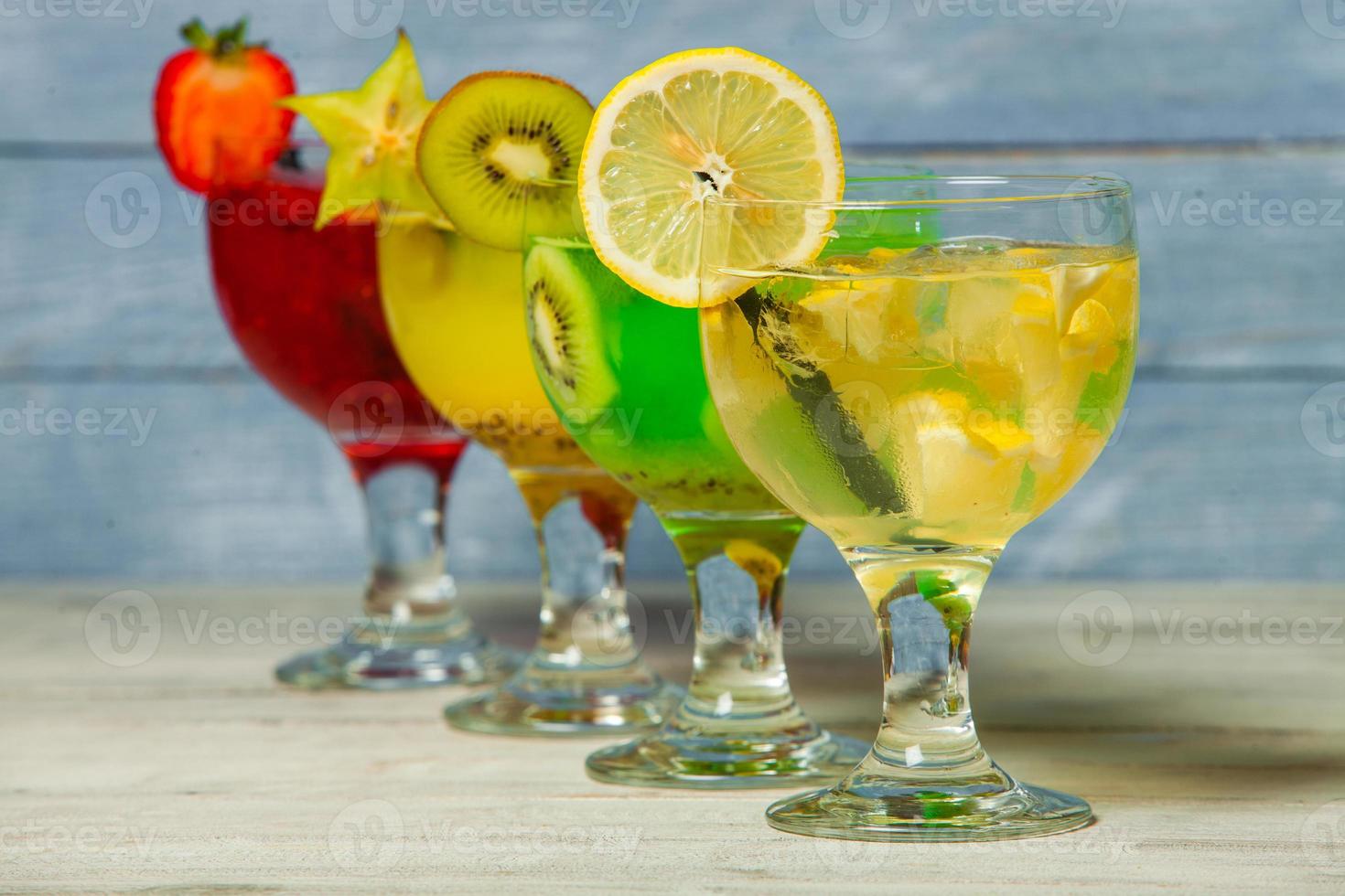 divers cocktails alcoolisés sur fond blanc. cocktails colorés se bouchent. cocktail de jus de fruits. cocktails assortis. verres de boissons aux fruits avec des glaçons sur la table au café photo