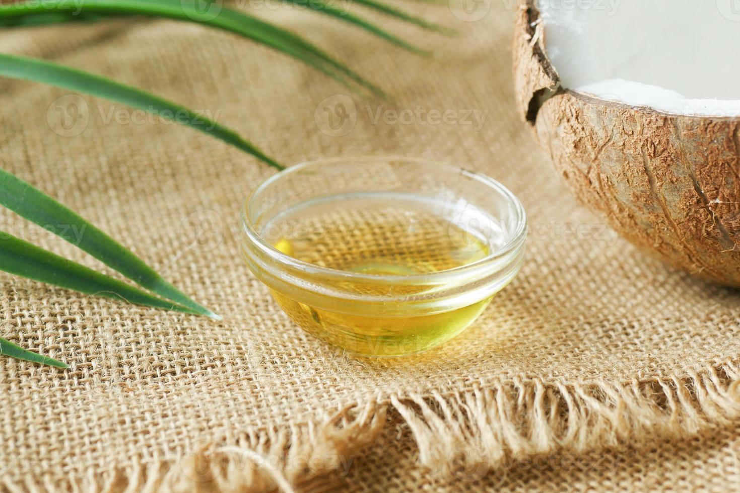 tranche de noix de coco fraîche et bouteille d'huile sur une table photo